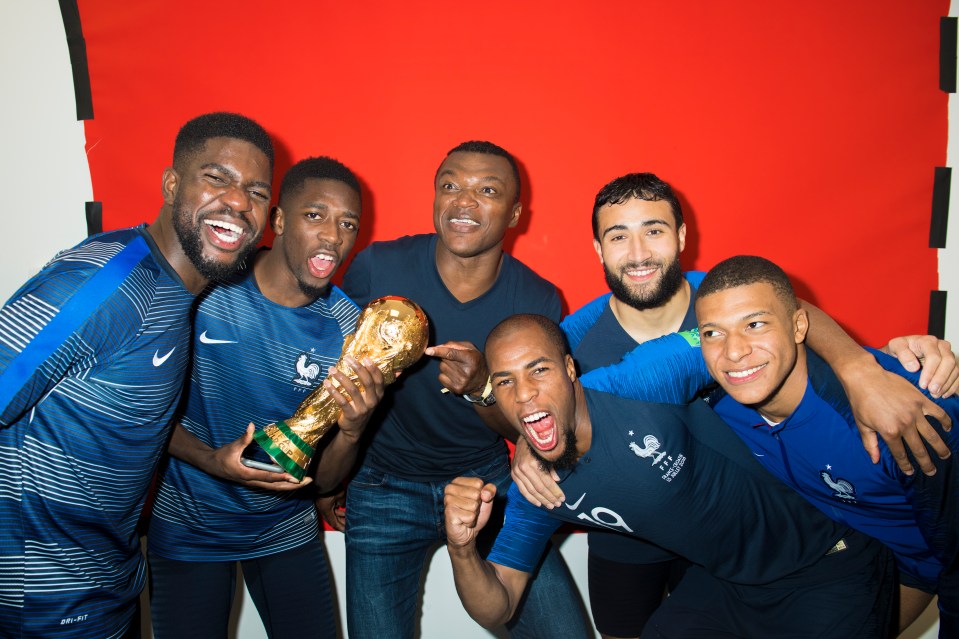 a group of soccer players are posing for a picture and one of them is holding a trophy