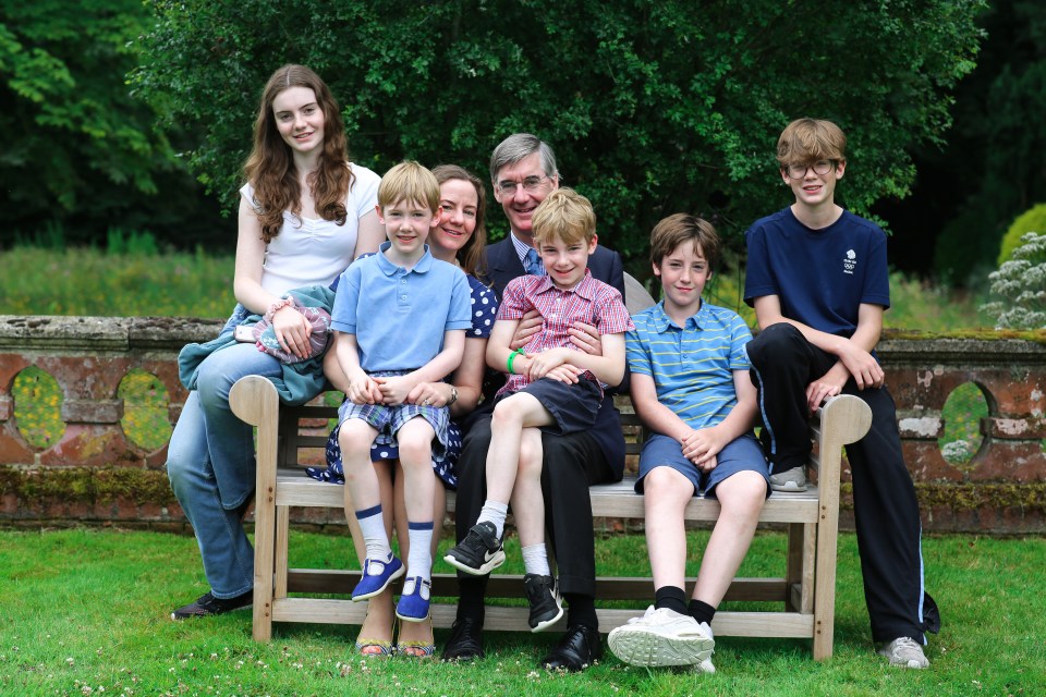 a family posing for a picture while sitting on a wooden bench