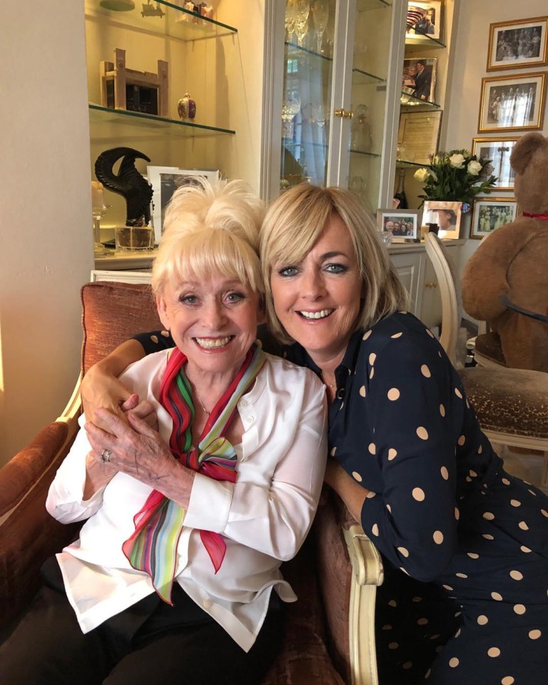 two women are posing for a picture in a living room