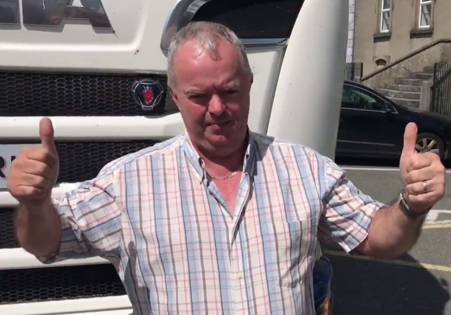 a man giving a thumbs up in front of a scania truck