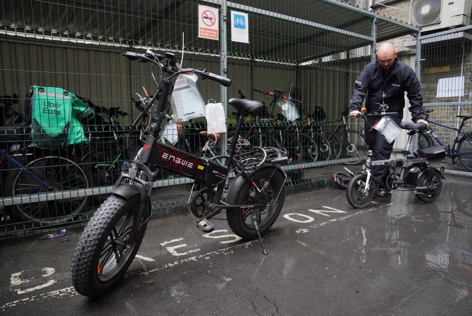 Sergeant Chris Hook handles confiscated illegally modified ebikes at Bishopsgate Police Station in London