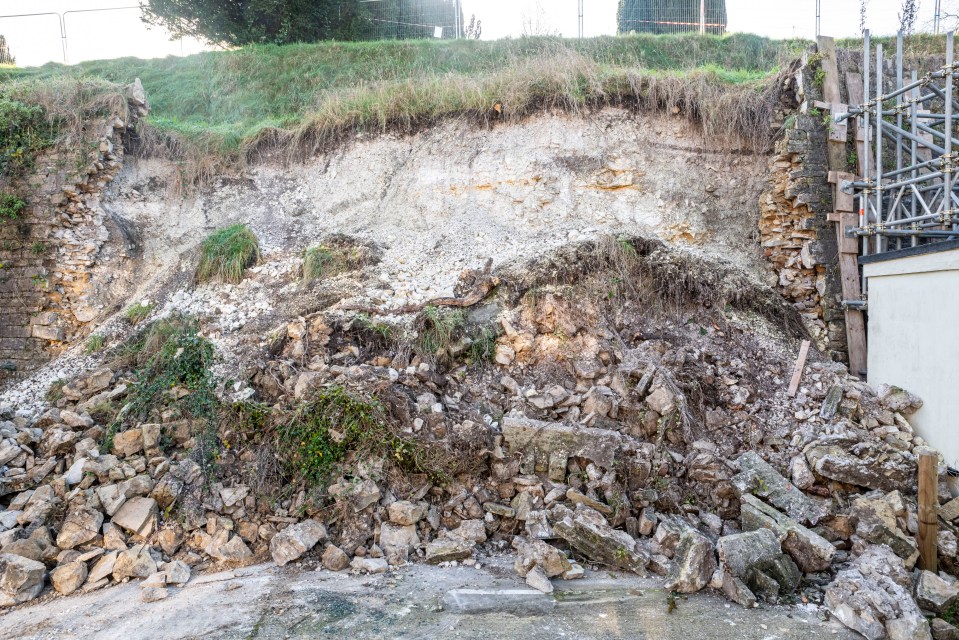 a large pile of rocks sits on a hillside