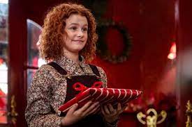 a young girl with curly hair is holding a pair of scissors .