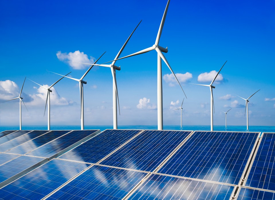 a row of wind turbines and solar panels against a blue sky