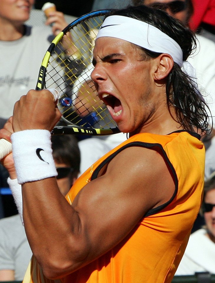 a man wearing a nike wristband is holding a tennis racquet