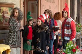 a group of people are standing in front of a building wearing elf hats .