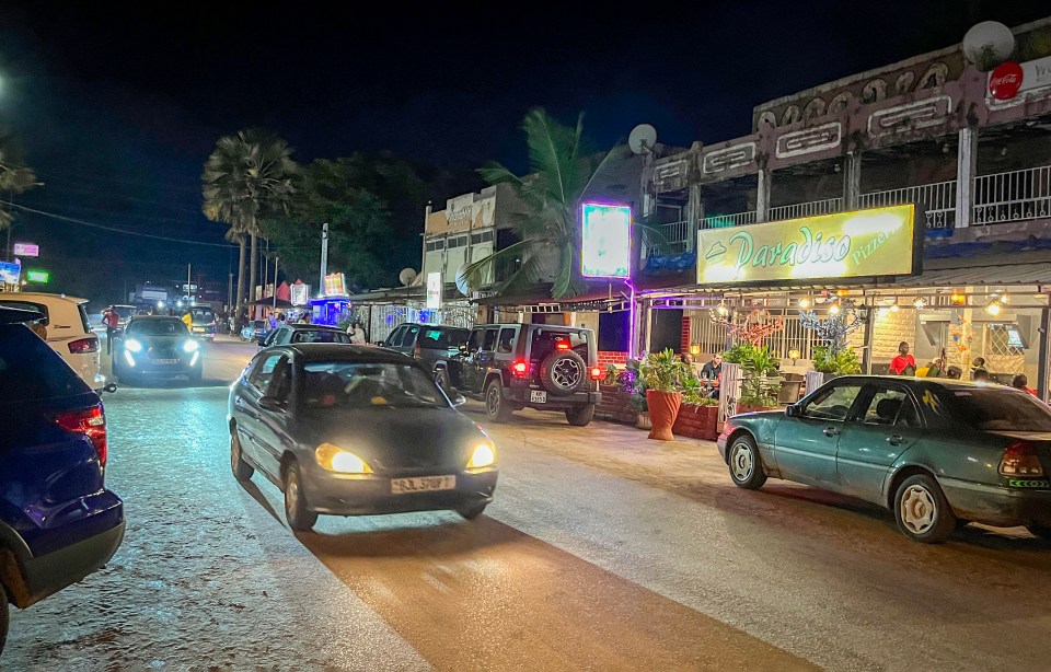 cars are parked in front of a sign that says paradise