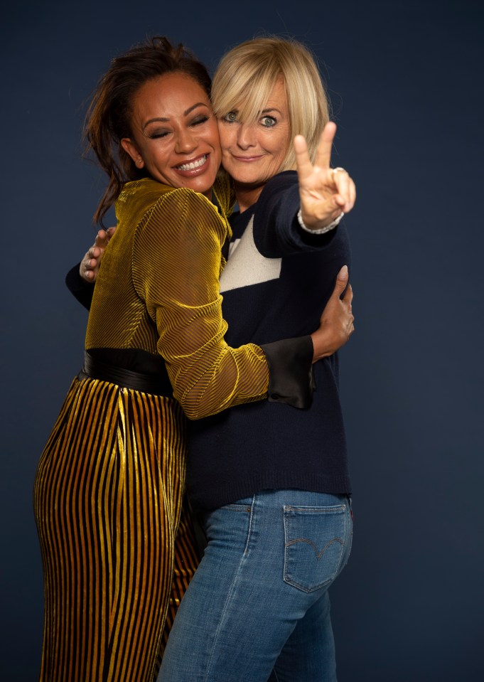 two women posing for a picture with one giving a peace sign