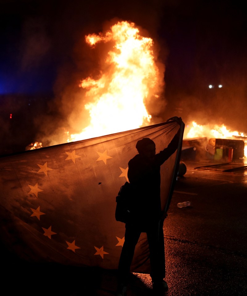 A supporter of Georgia’s opposition holds a European Union flag while attending protests last night