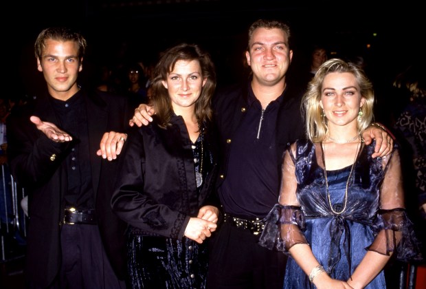 a group of people posing for a picture with one woman wearing a blue dress