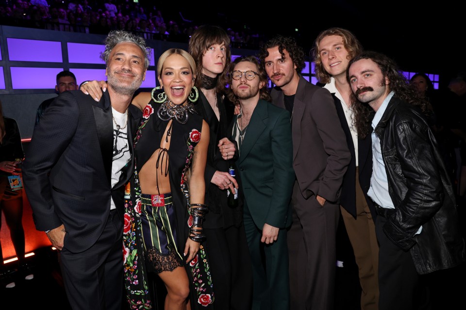 Backstage she posed with her husband Taika Waititi in a floral motif filled outfit