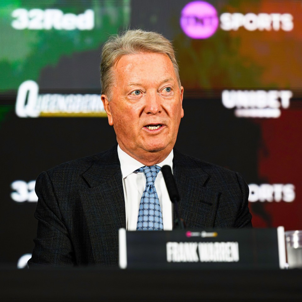 a man in a suit and tie stands behind a podium that says frank warren