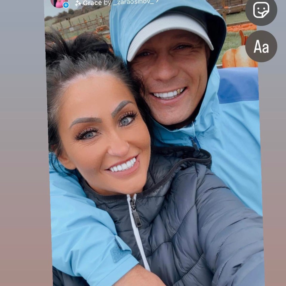 a man and a woman are posing for a picture and the woman is wearing a blue jacket