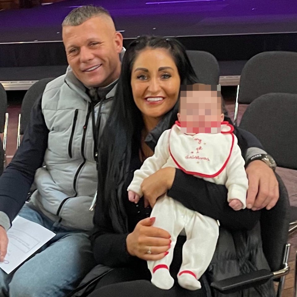 a woman holding a baby with a bib that says christmas on it