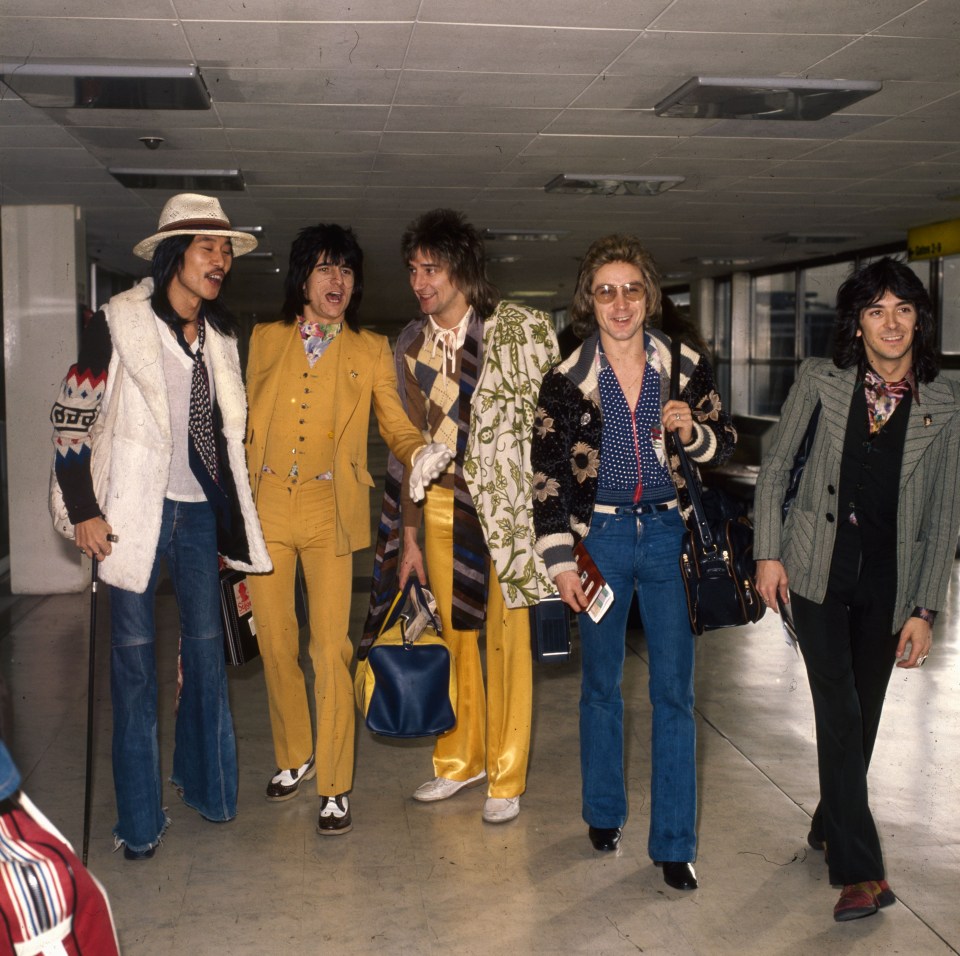 a group of men are walking together in a hallway