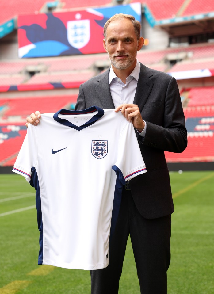 a man in a suit holds up a white nike shirt