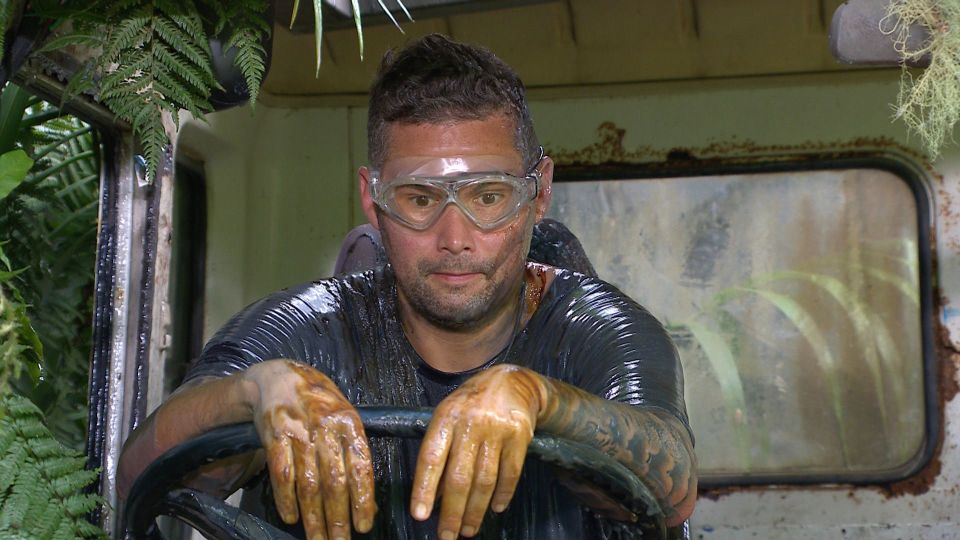 a man wearing goggles is sitting in a vehicle with his hands on the steering wheel