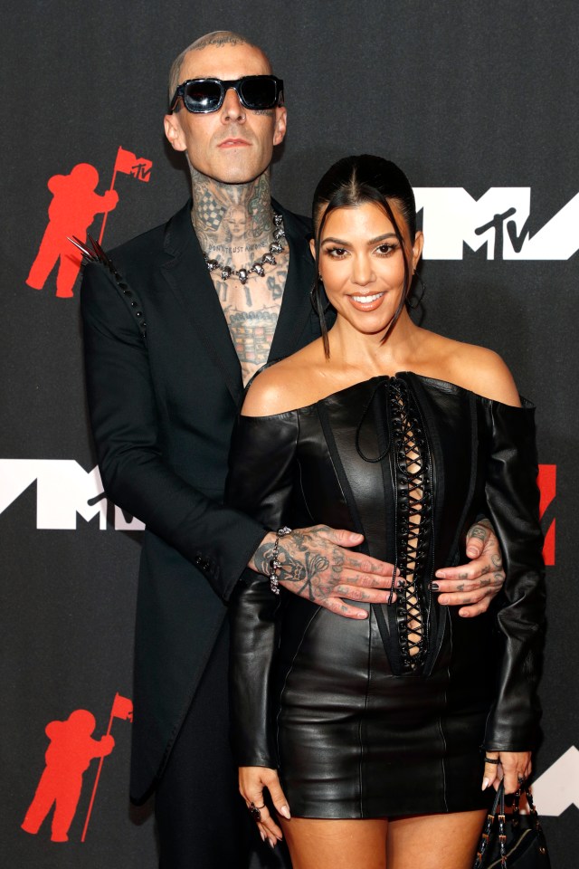 a man and woman pose on a red carpet with a mtv logo in the background