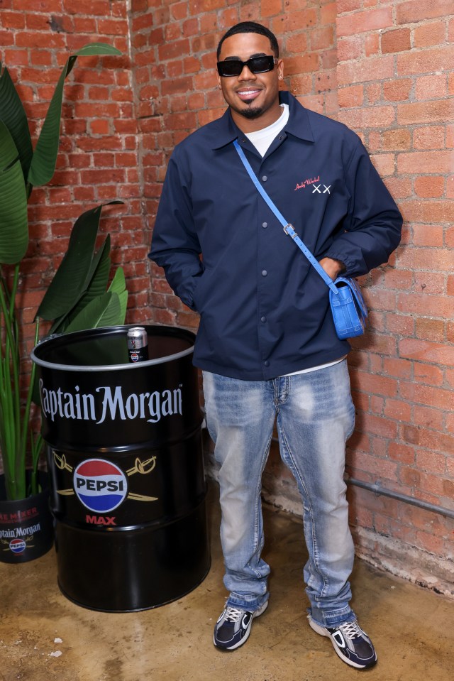 a man standing in front of a pepsi max barrel