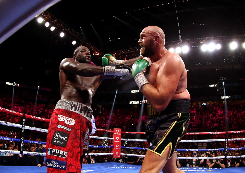 two boxers in a boxing ring one of whom is wearing shorts that say pure