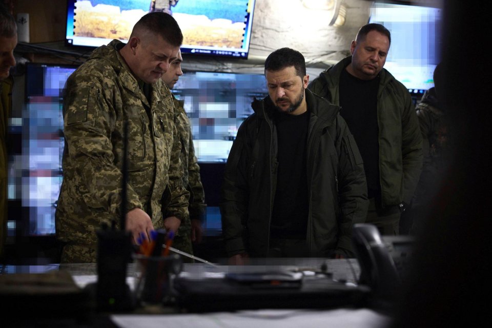 a group of men in military uniforms are looking at a computer monitor