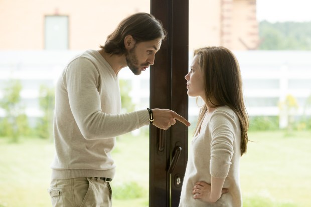 a man is pointing at a woman in front of a door