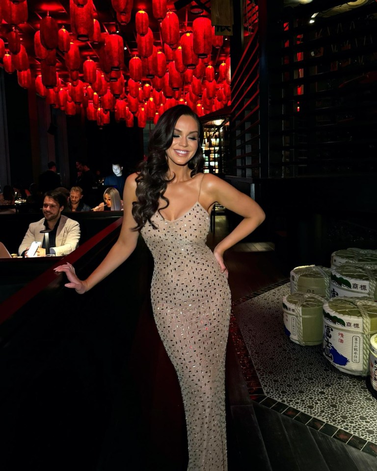 a woman in a long dress is standing in a restaurant