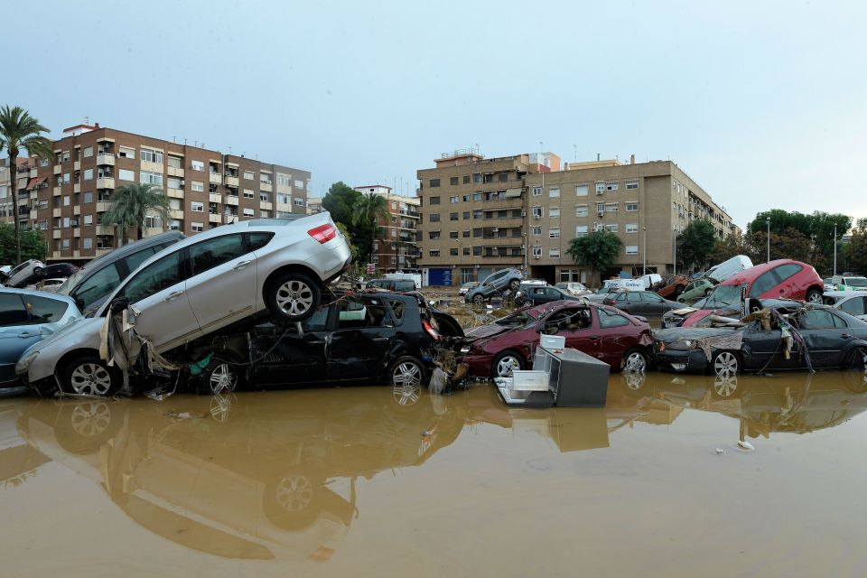 a bunch of cars are stacked on top of each other in a flooded area