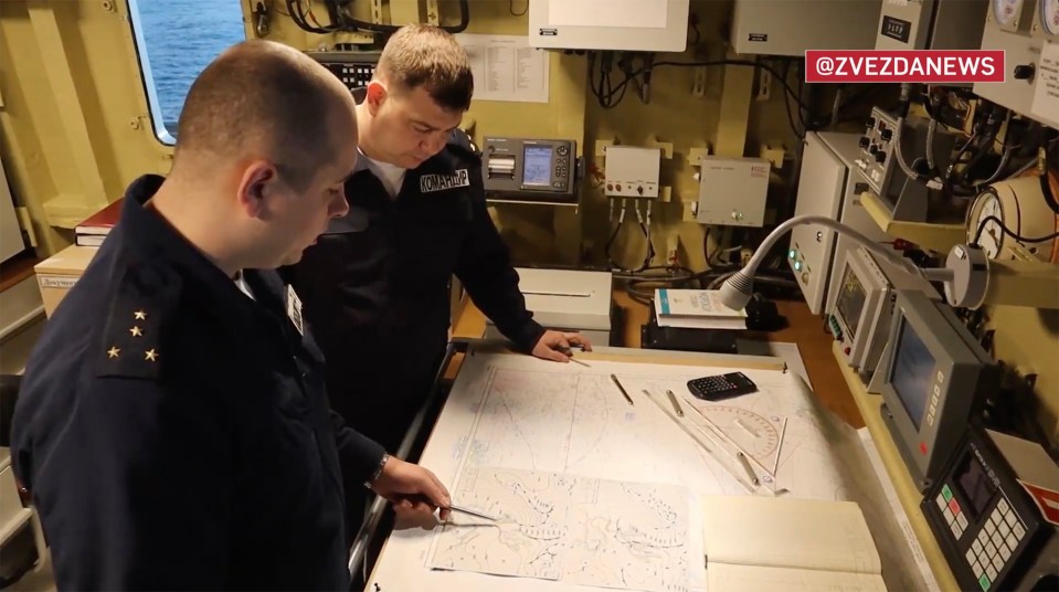 Russian naval bosses looking at maps on board the warship