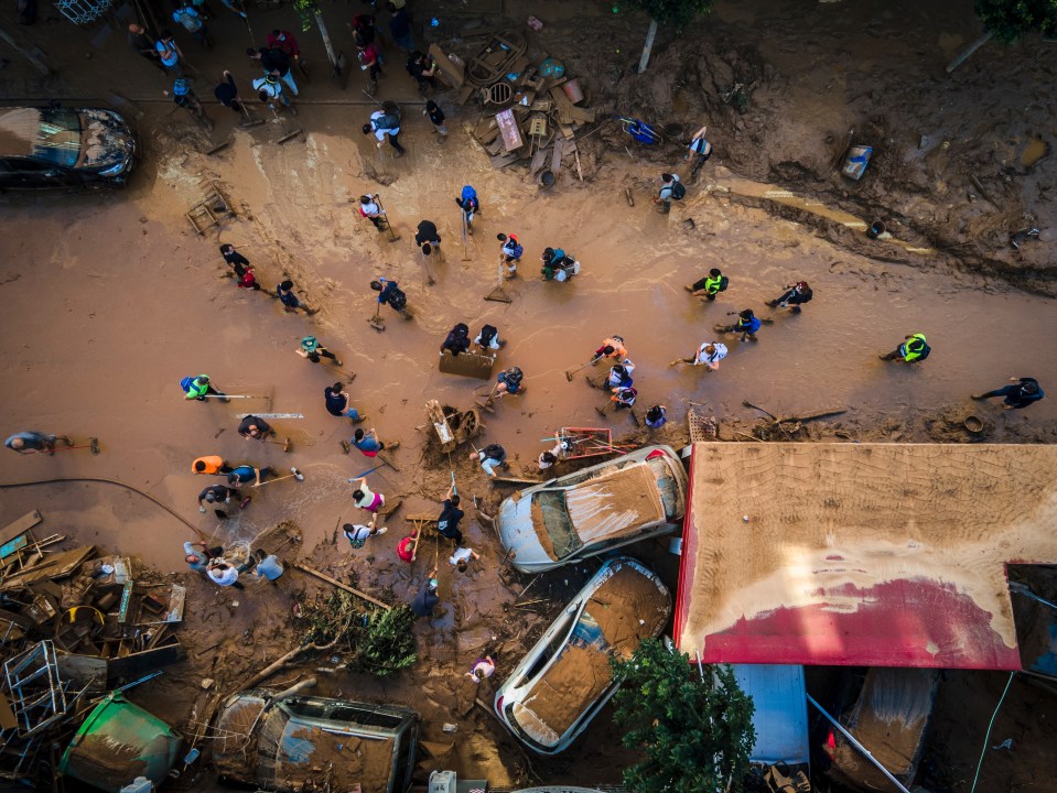 a group of people are walking through a flooded area