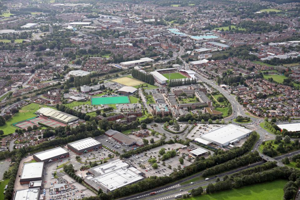 an aerial view of a city with a green field in the middle