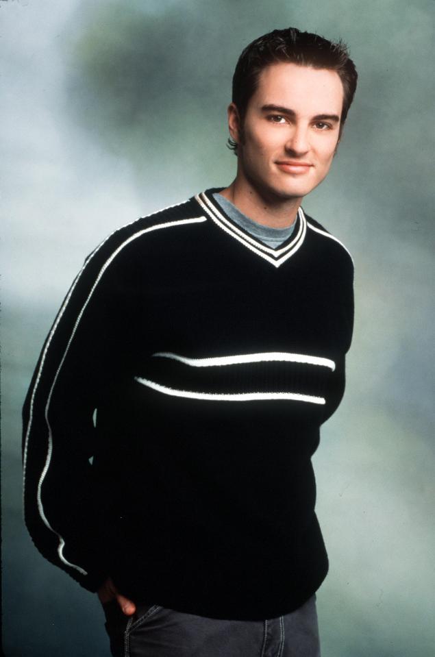 a young man wearing a black sweater with white stripes on the sleeves