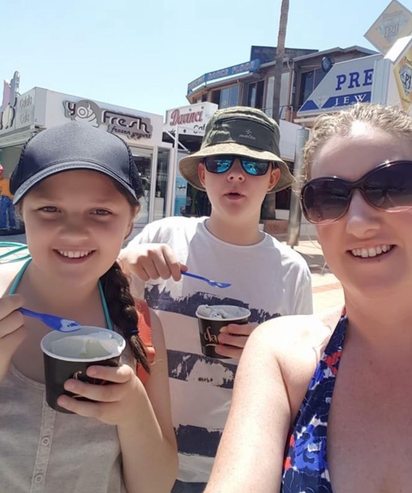 a woman and two children are eating ice cream in front of a sign that says pre jew