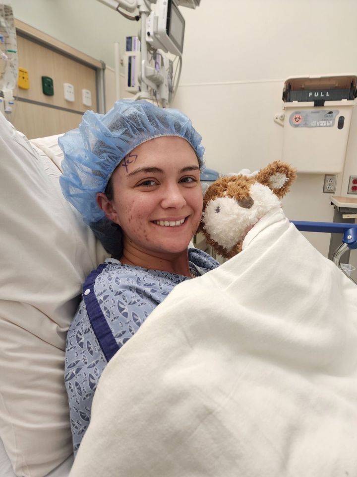 a woman in a hospital bed with a teddy bear