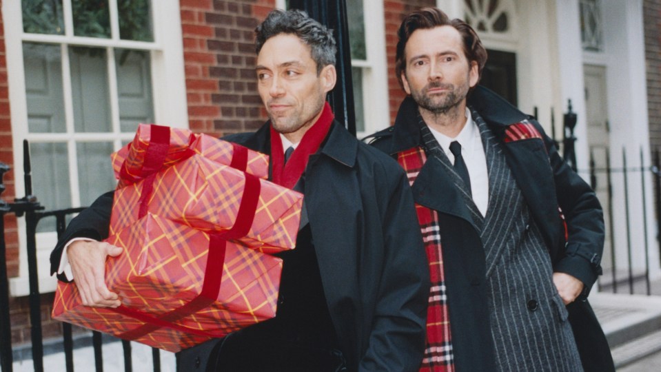 two men standing next to each other one holding a gift