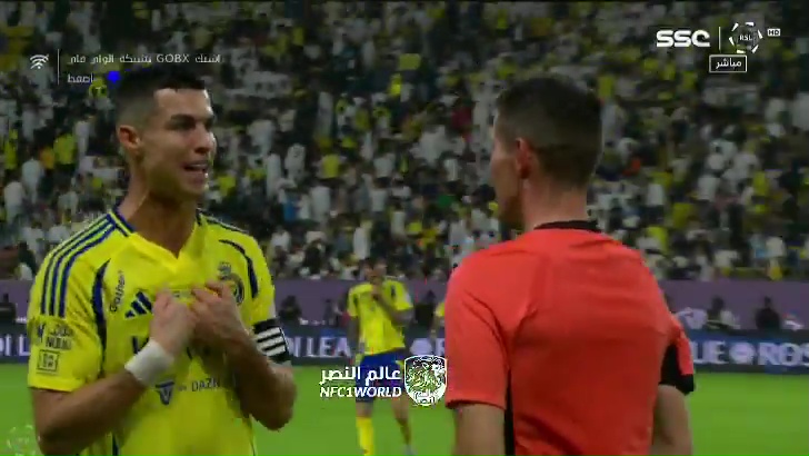 a soccer player in a yellow adidas jersey talks to a referee