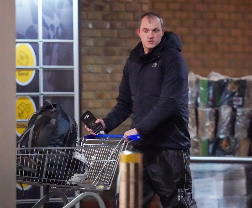 a man is pushing a shopping cart with a bag in it