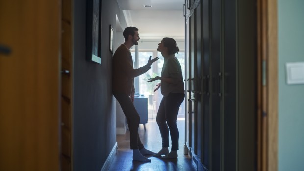 a man and a woman are having an argument in a hallway