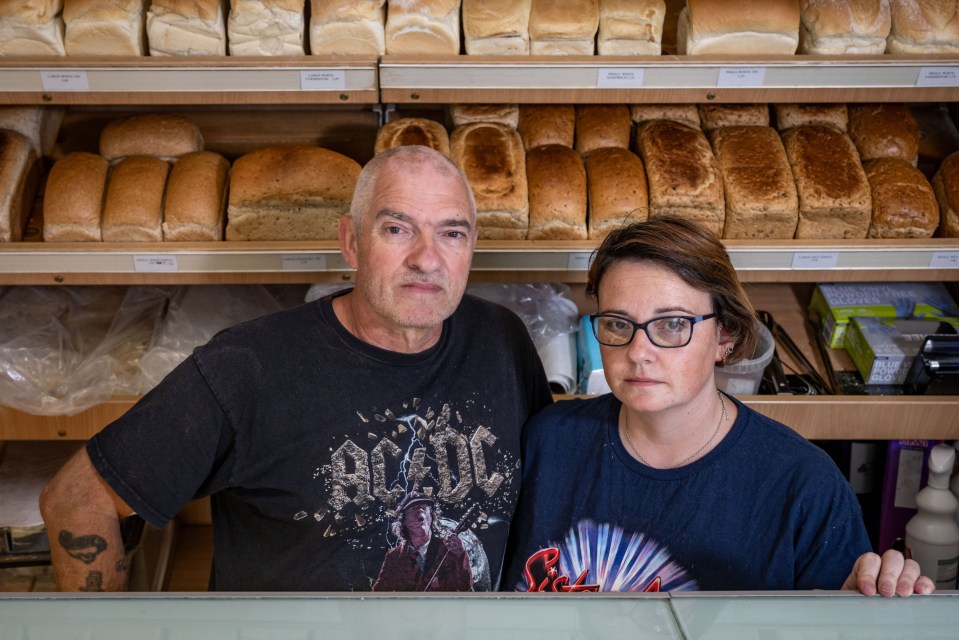 Owners of a family-run bakery stand behind a display of bread.