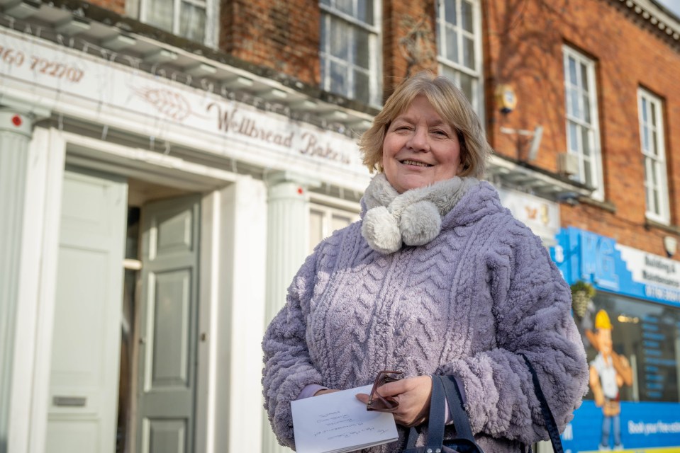 Woman holding petition against Greggs opening near Wellbread Bakers.