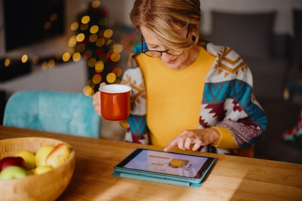 Woman online Christmas shopping on tablet.