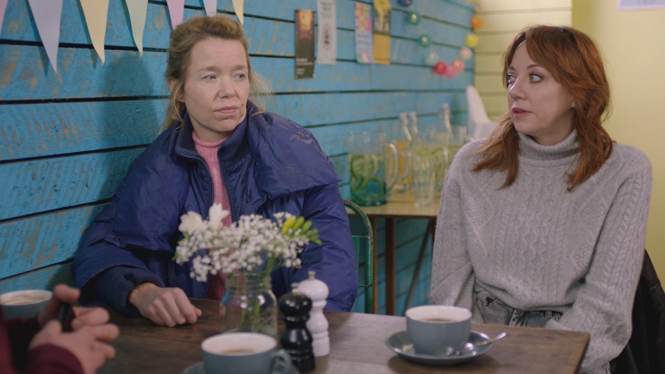 Anna Maxwell Martin and Diane Morgan, from the TV series Motherland, seated at a cafe table.