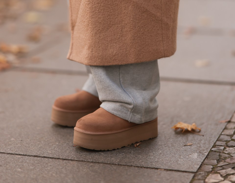 Person wearing beige coat, gray joggers, and beige platform boots.