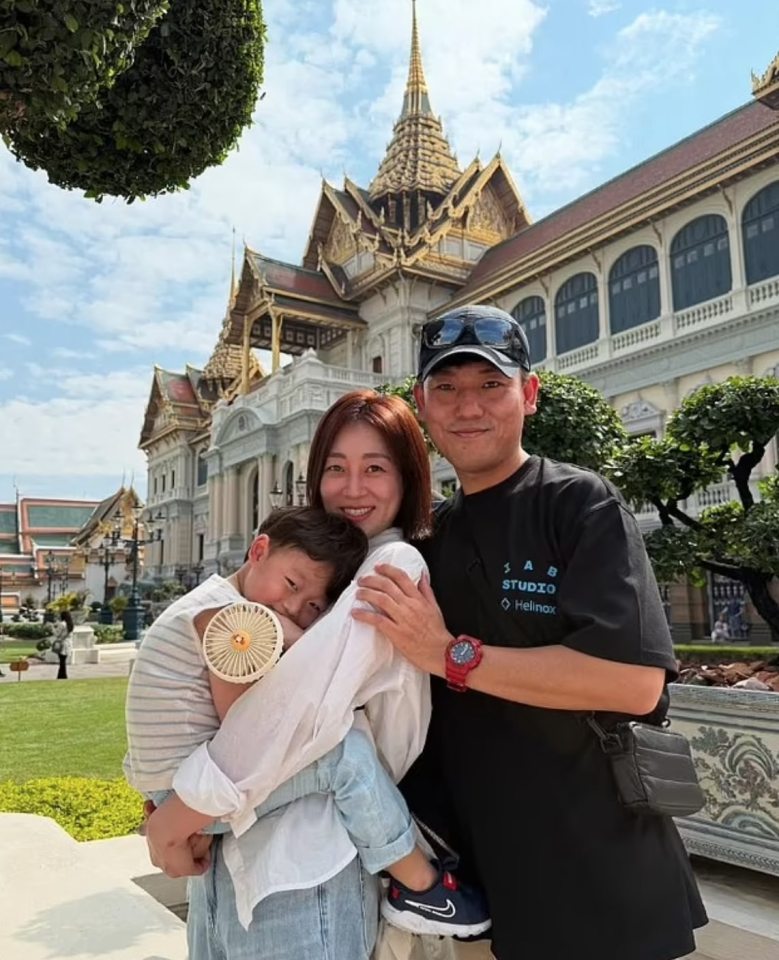 Family photo in front of a palace in Thailand.