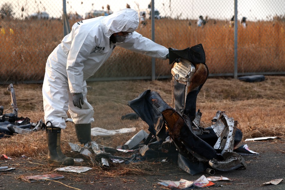 A member of the investigation team inspects a burnt seat