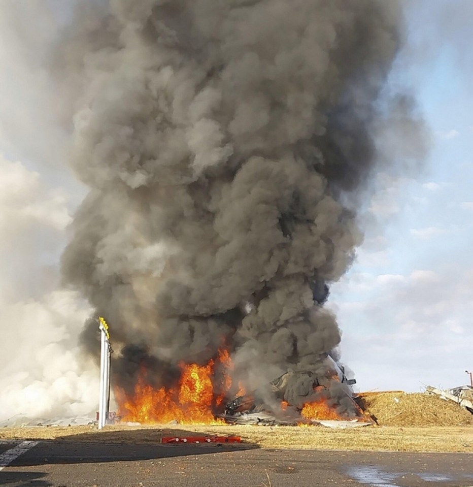 Burning wreckage of a plane crash at an airport.