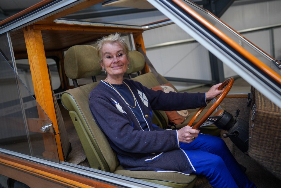 Woman sitting in a wooden car.