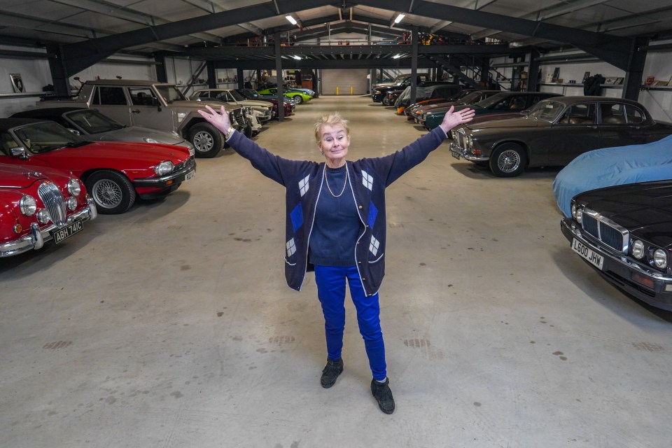 Woman standing in her large car collection garage.