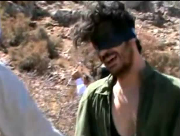 An image grab taken from a video on YouTube shows American freelance journalist Austin Tice blindfolded with men believed to be his captors at an undisclosed location in Syria