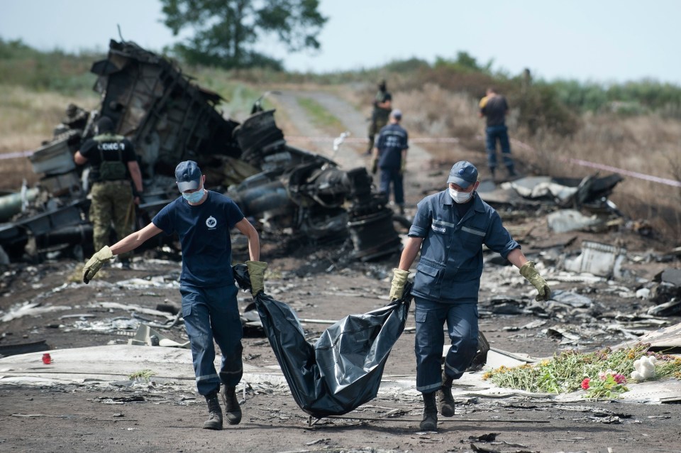 Ukrainian Emergency workers carry a victim’s body in a body bag at the crash site of Malaysia Airlines Flight MH17